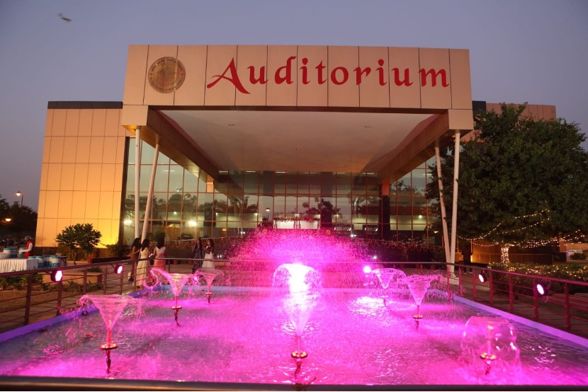 The AIIMS Jodhpur auditorium at dusk, with the fountain lit